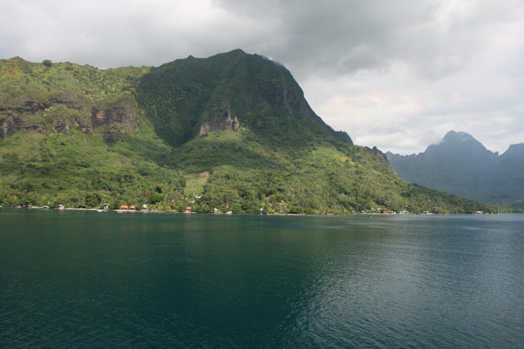 Mountain and lake under cloudy sky.