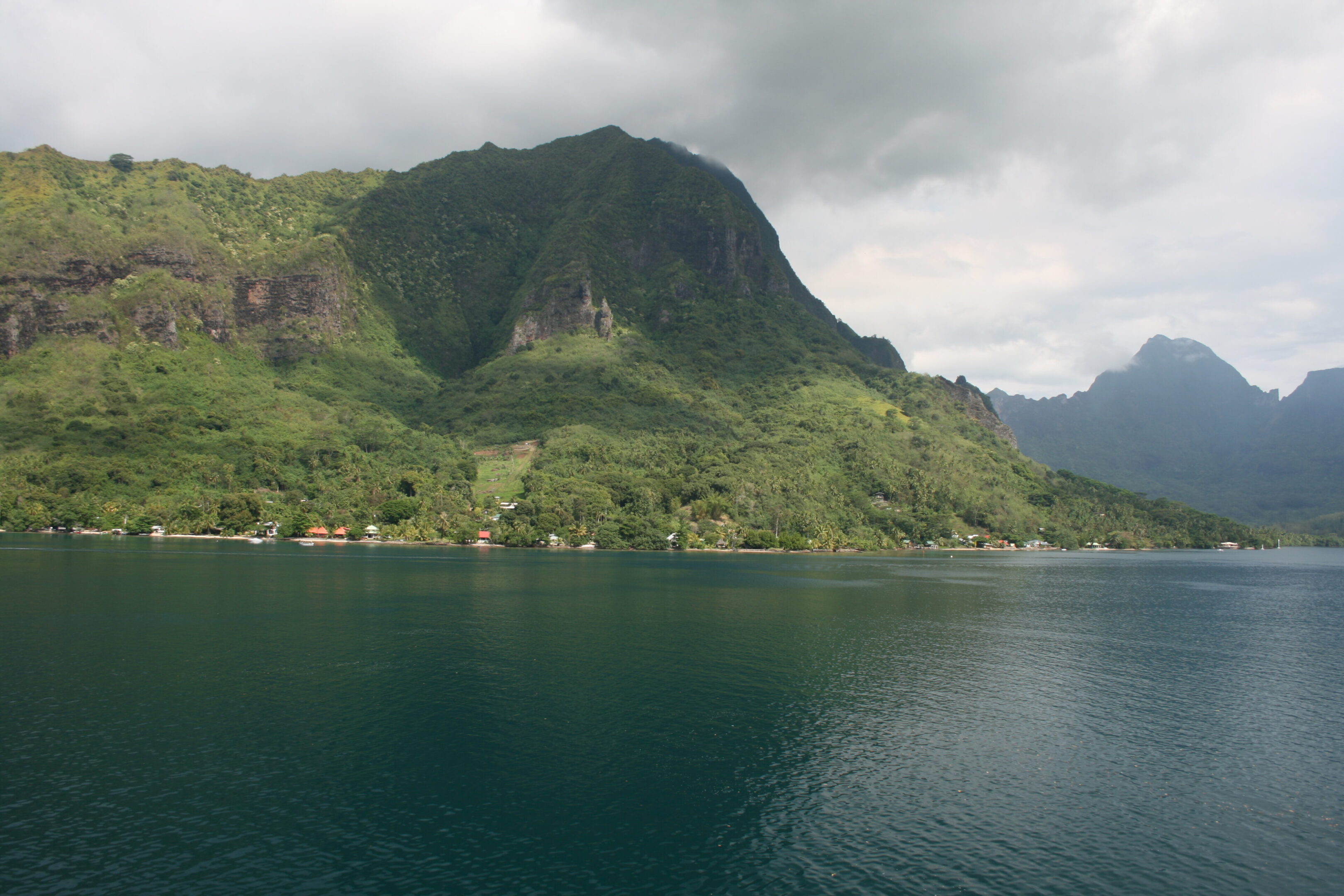 Mountain and lake under cloudy sky.