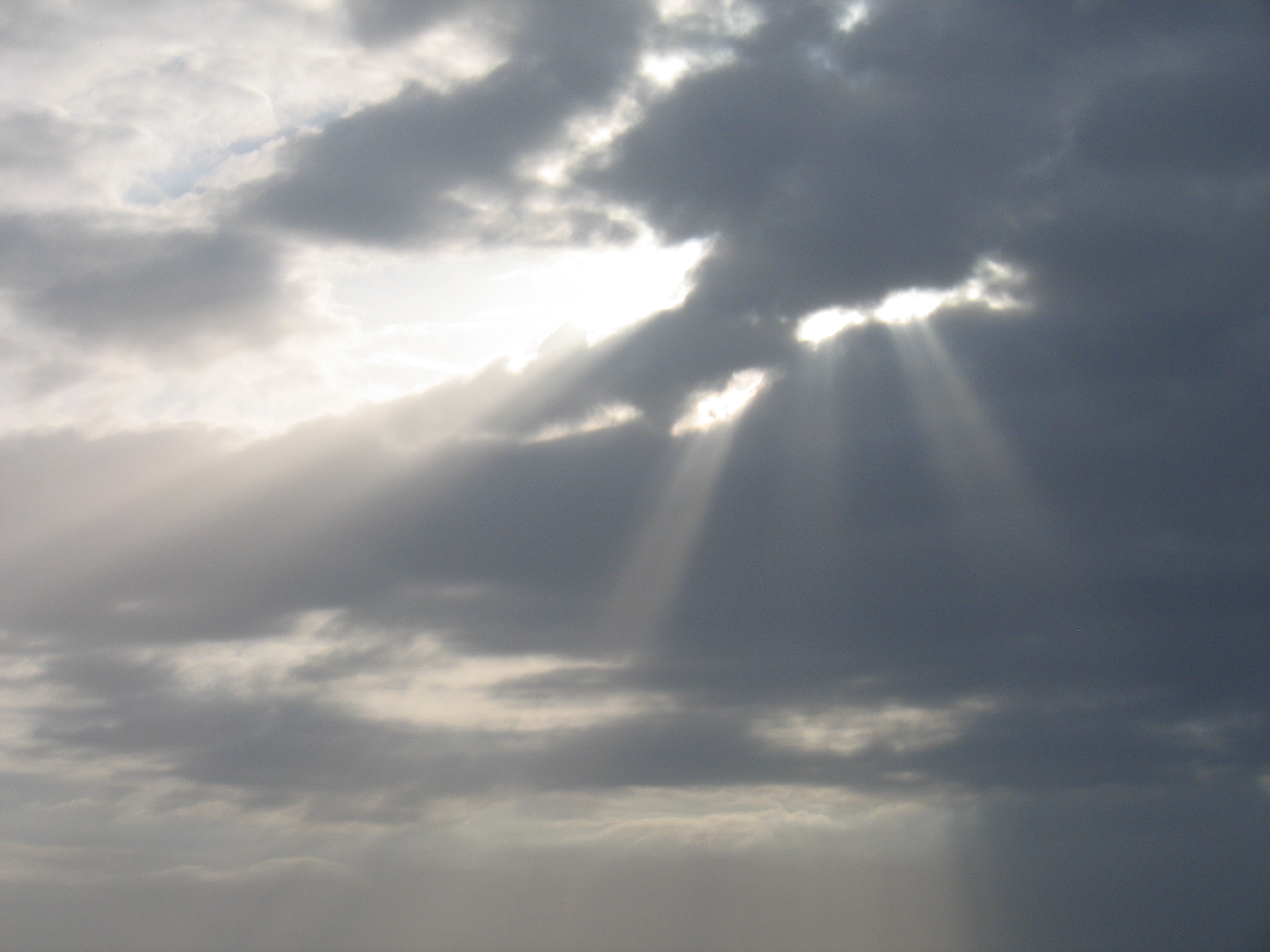 Sunlight streaming through cloudy sky.