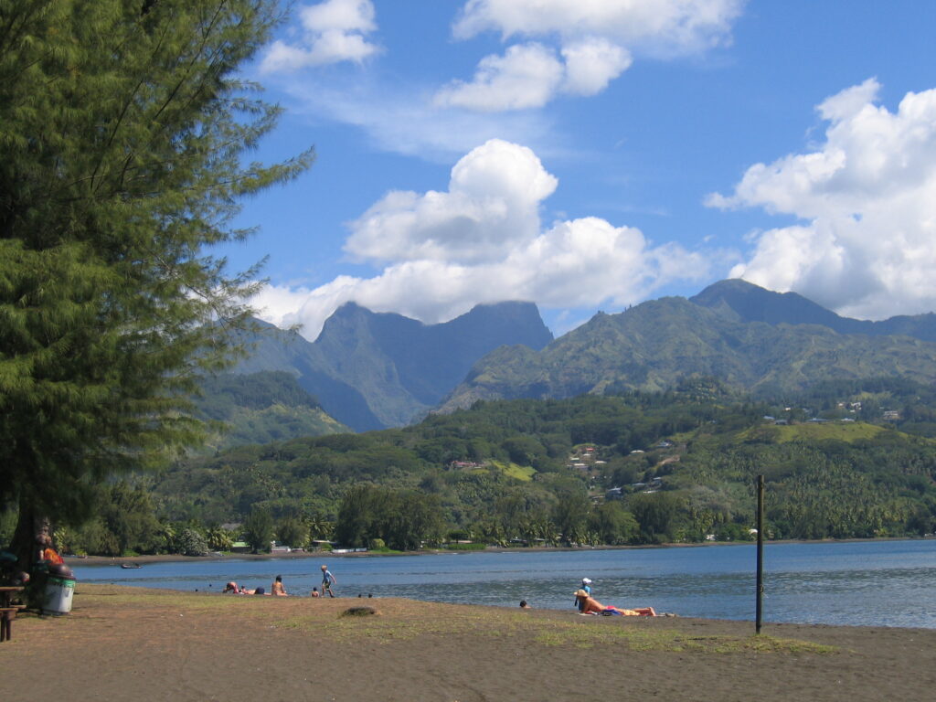 Beach with mountains and blue sky background.