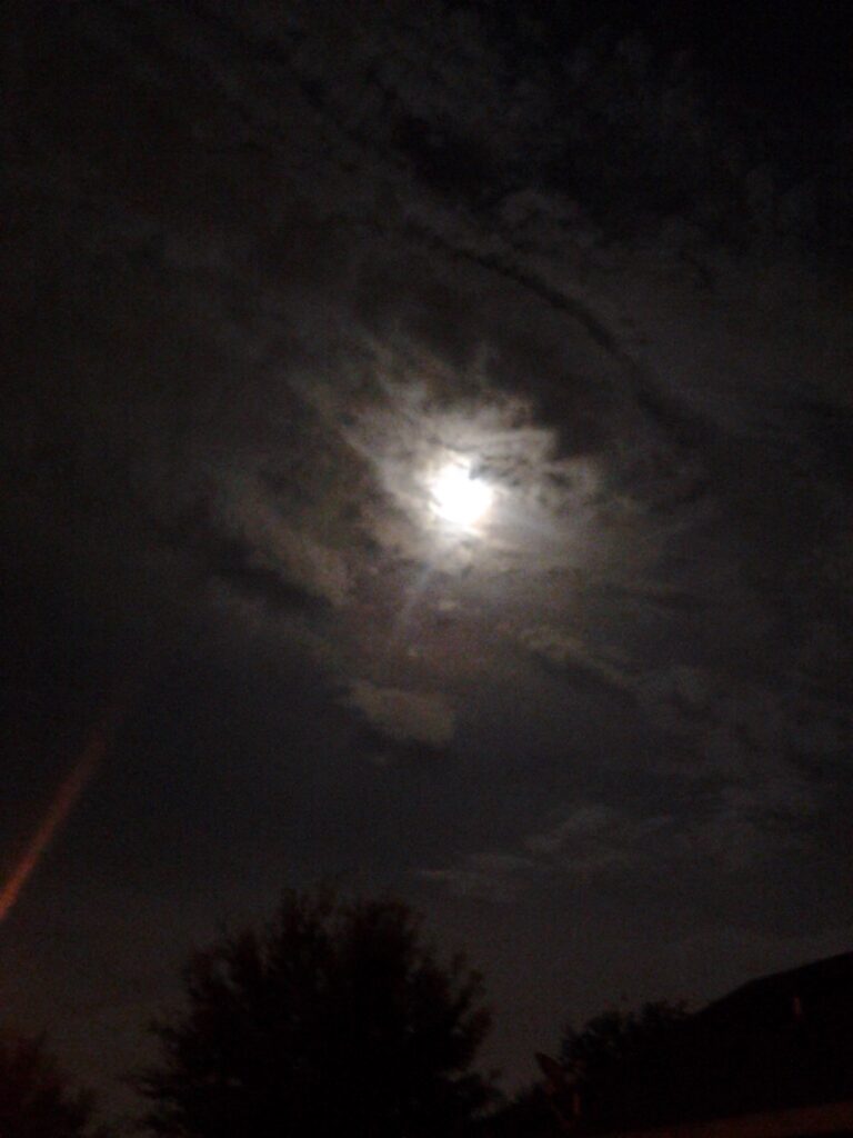 Cloudy night sky with bright moon.