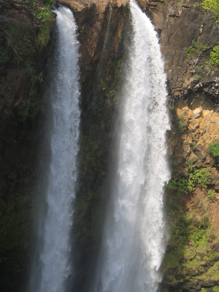 Twin waterfalls cascading over rocky cliffs.