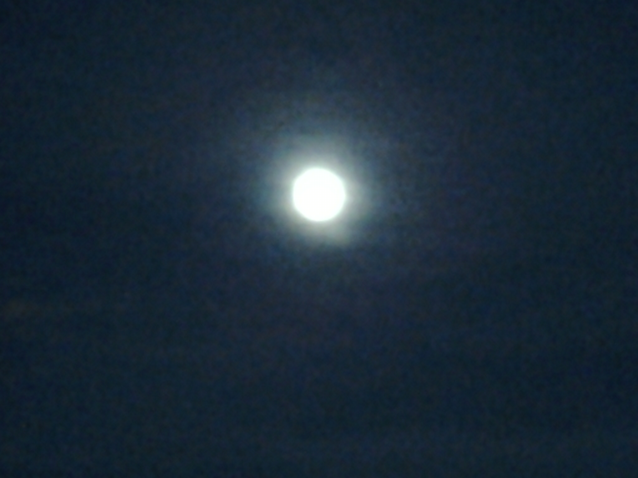 Blurry full moon in dark night sky.