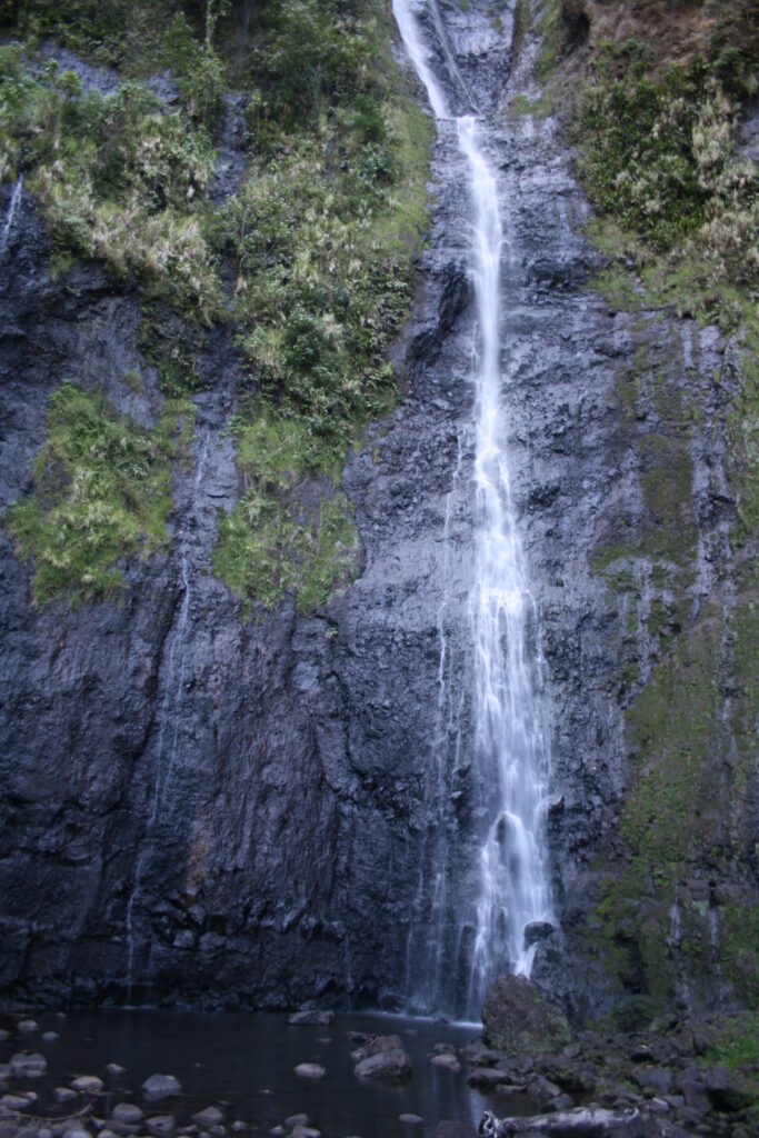 Tall waterfall cascading down rocky cliff.