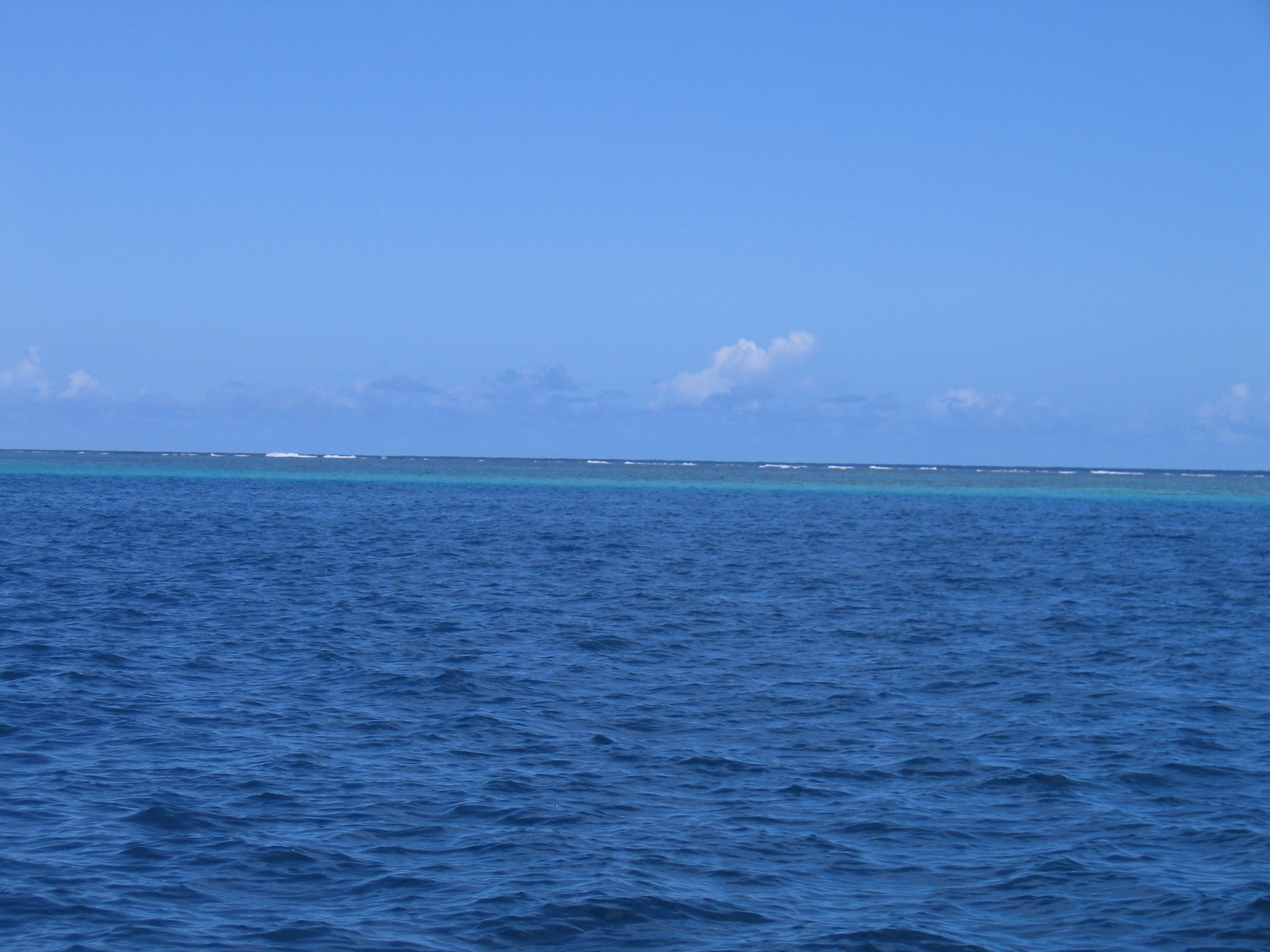 Blue ocean under clear sky horizon.