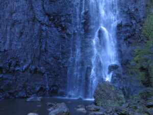 Waterfall cascading over dark rocky cliff.