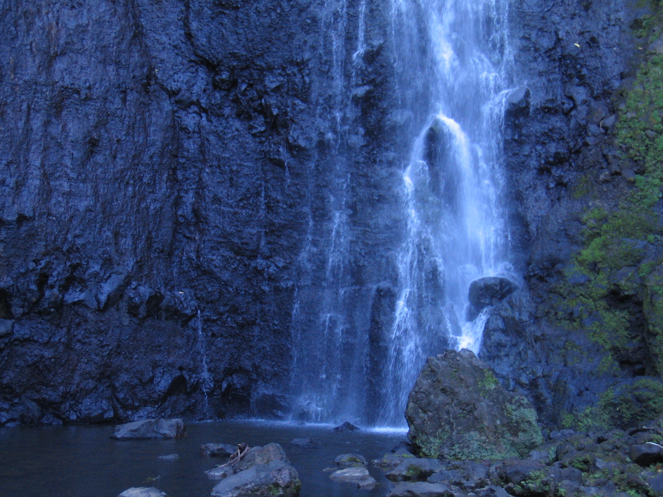 Waterfall cascading down rocky cliff face.