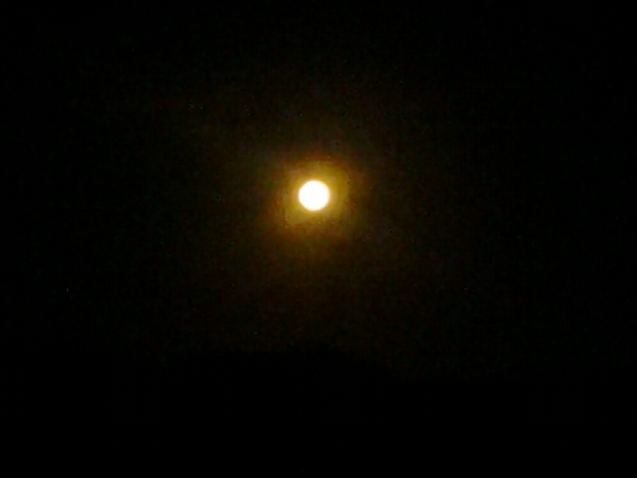Bright full moon in dark night sky.