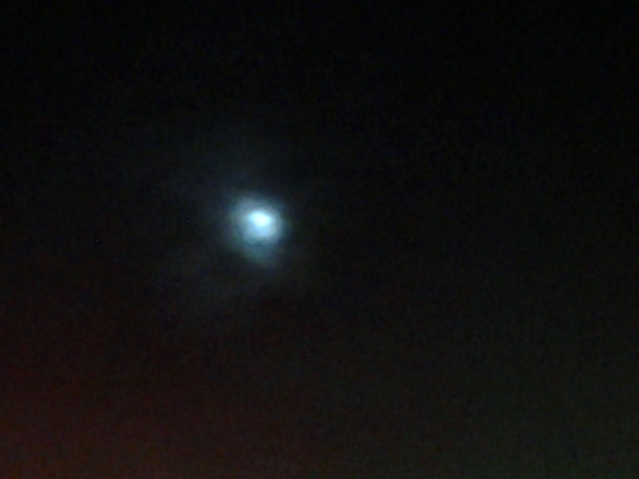 Faint moon in a dark, cloudy sky.