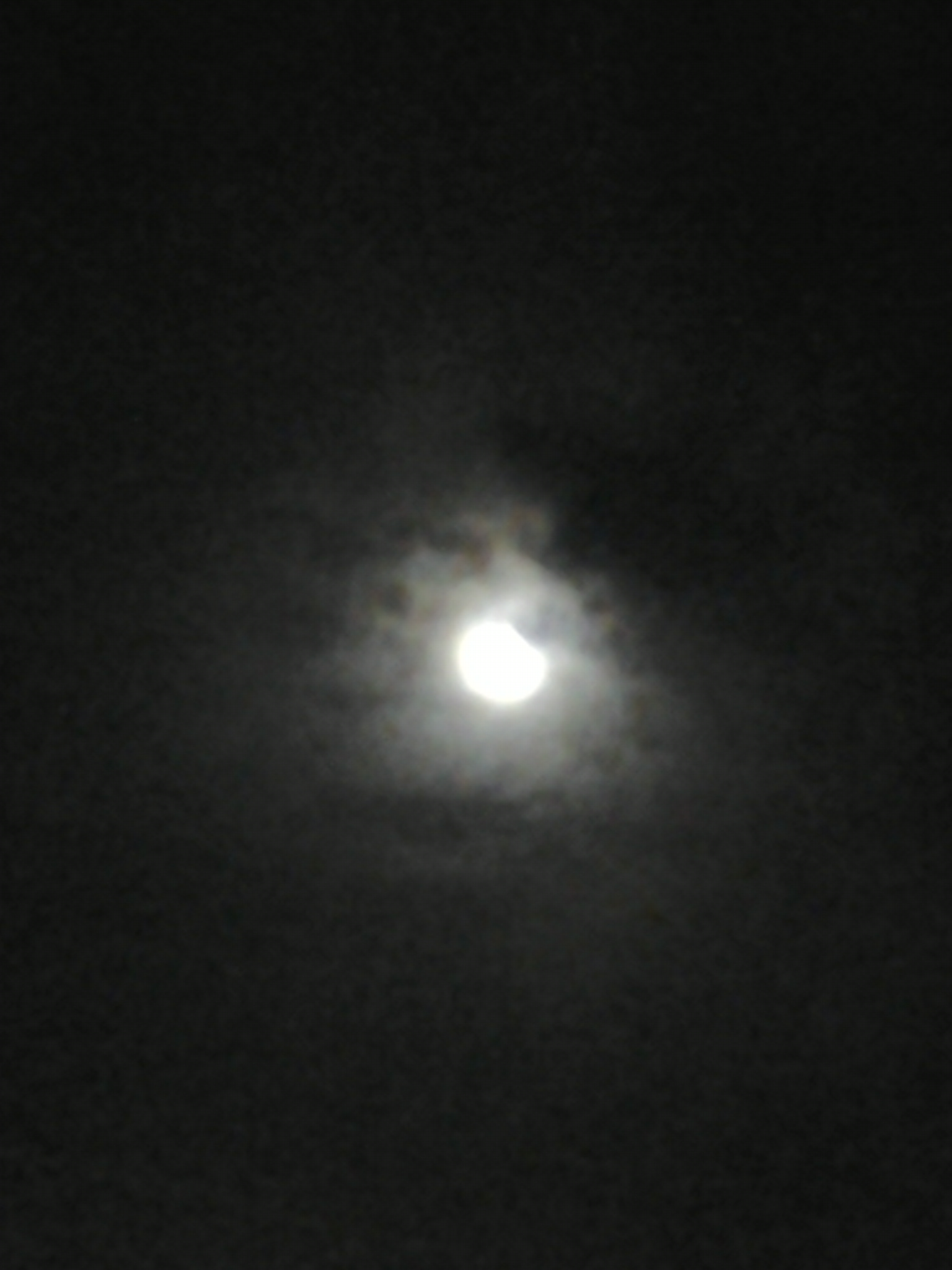 Cloudy night sky with partial moon.