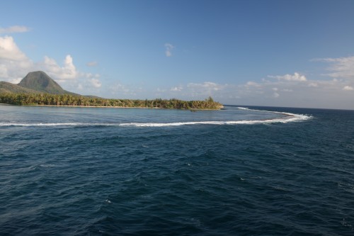 Coastal landscape with ocean and distant hills.