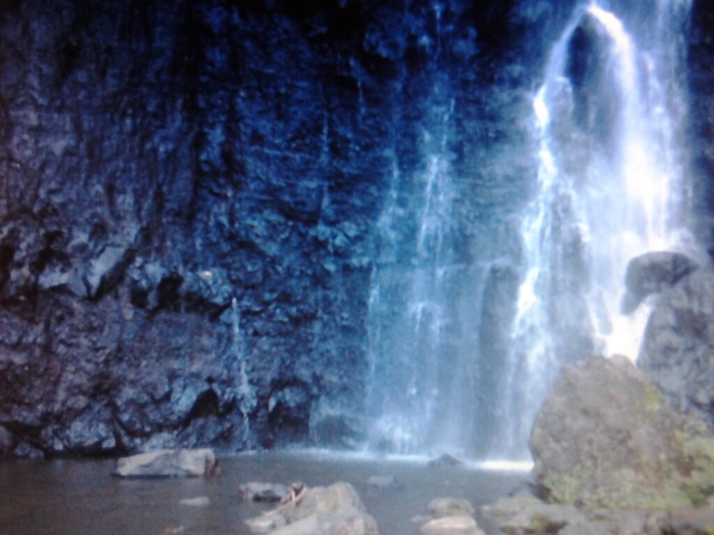 Waterfall cascading over dark rocky cliff.