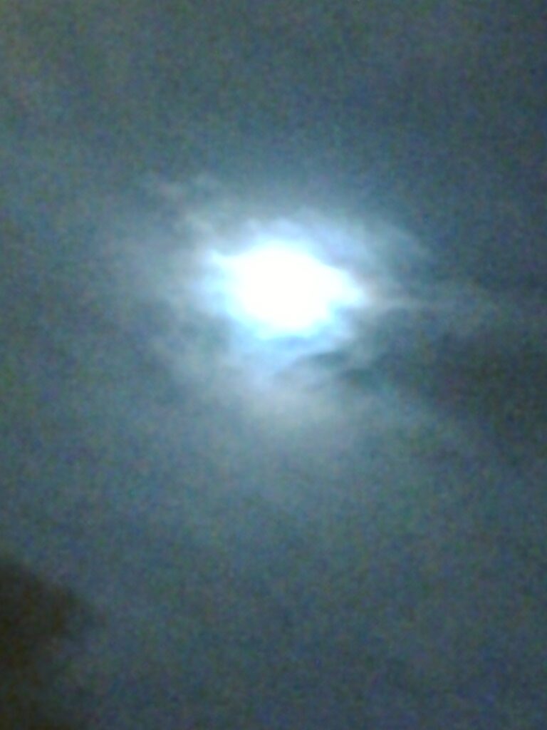Misty night sky with bright moon.