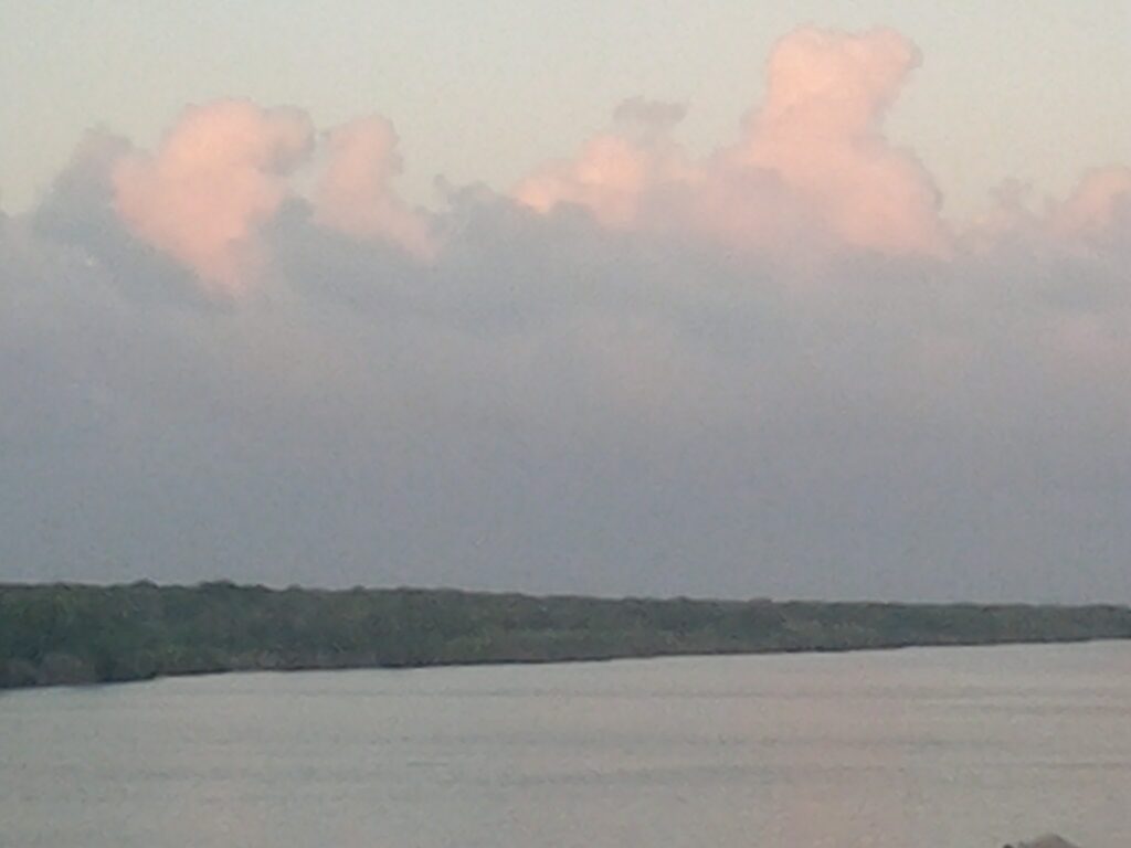 Calm river with pink clouds above.