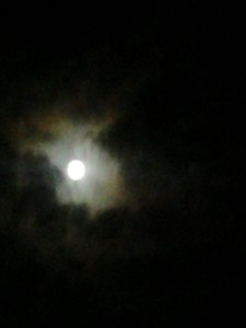 Full moon partially obscured by clouds.