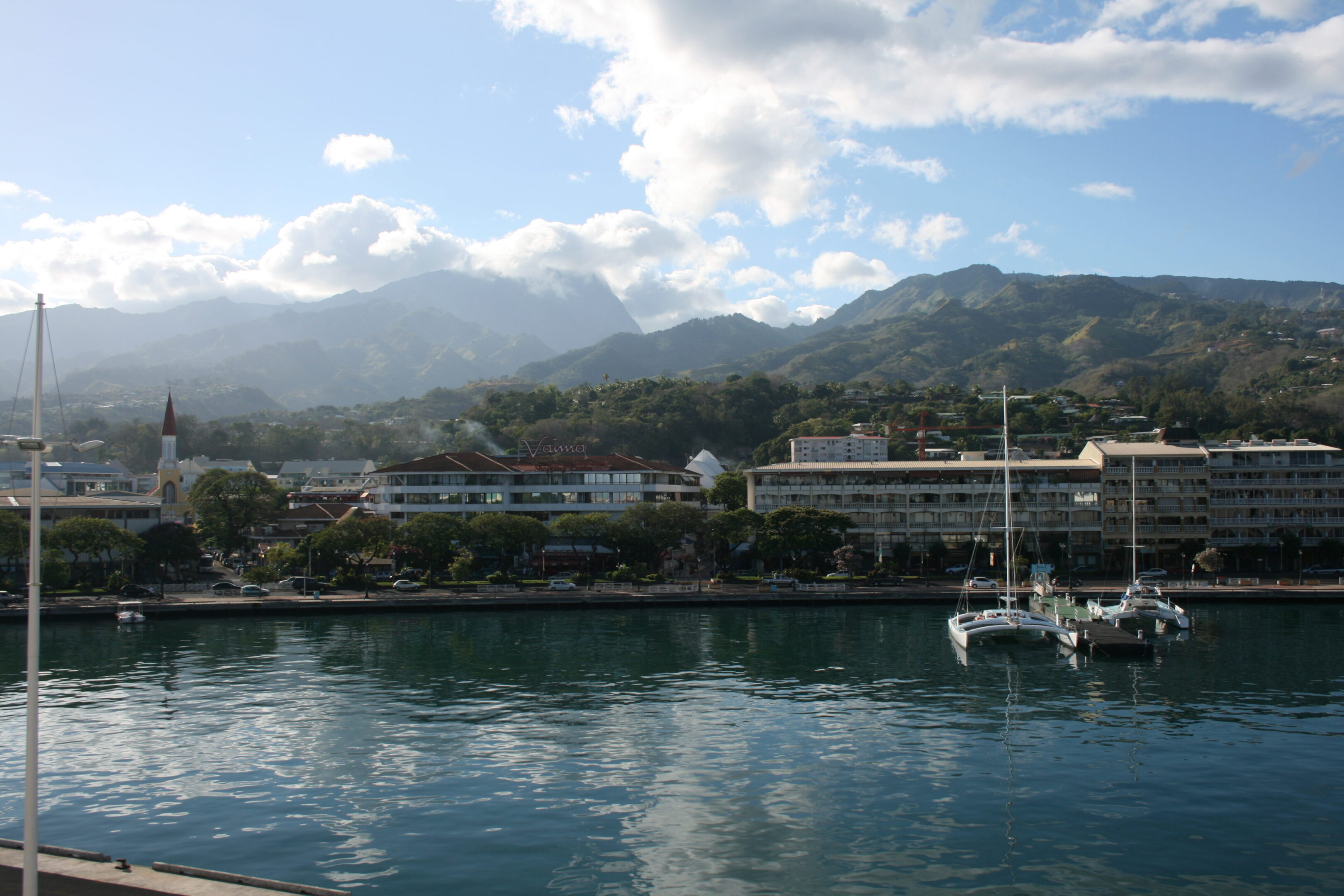 Harbor with mountains and buildings in background.
