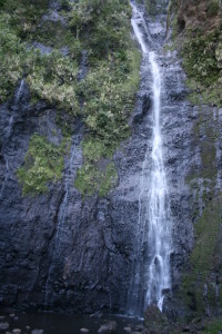 Tall waterfall cascading over rocky cliff.