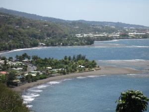 Coastal view with beach and distant hills.