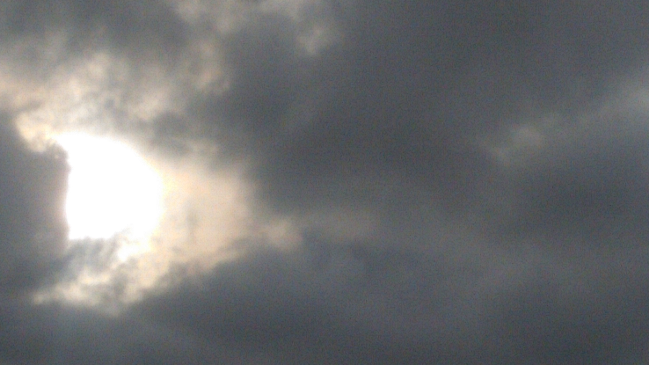 Cloudy sky with sun partially visible.
