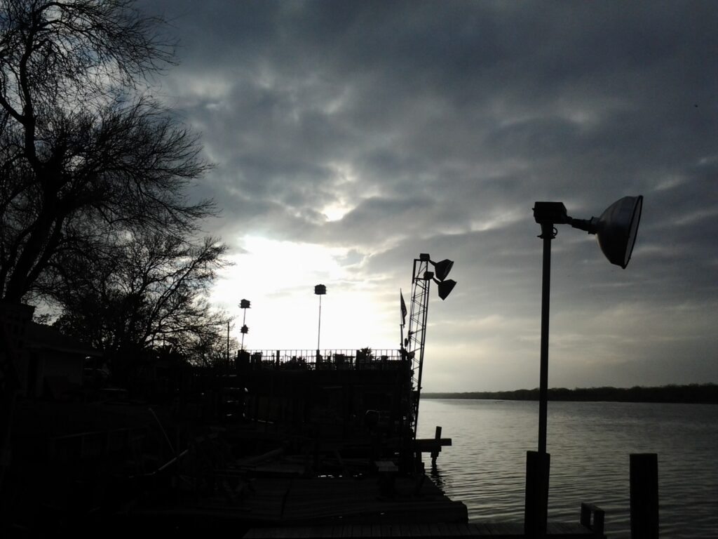 Silhouetted dock and trees at sunset.