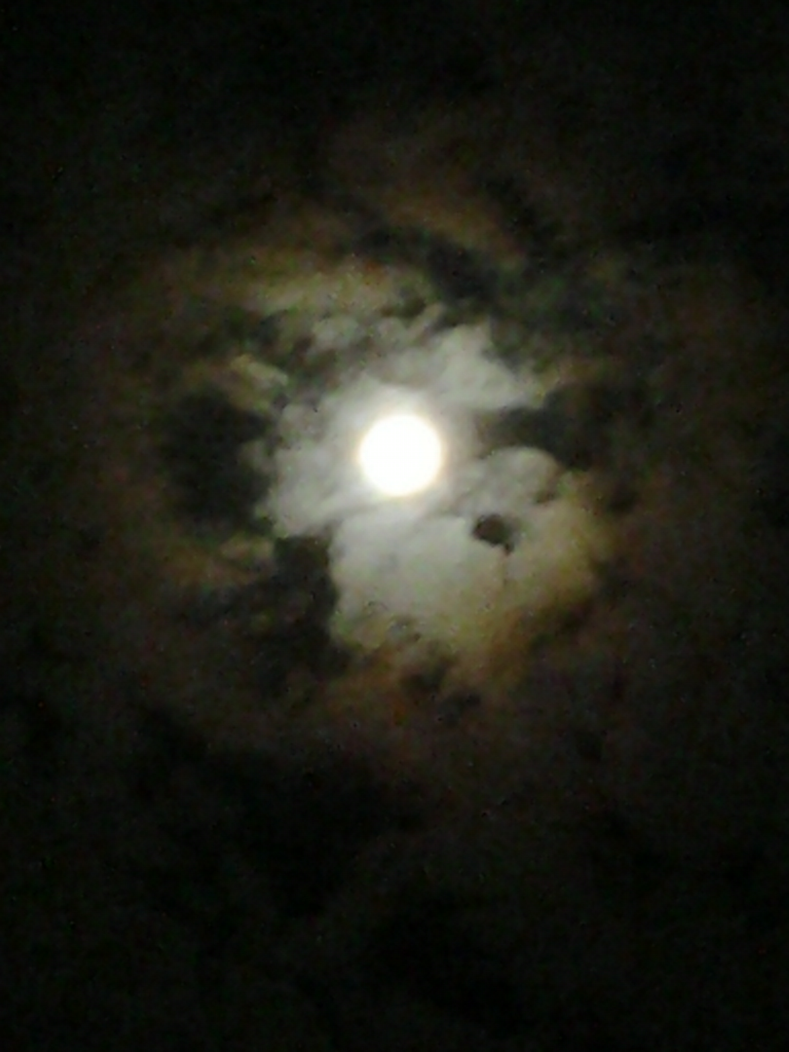 Full moon surrounded by swirling dark clouds.