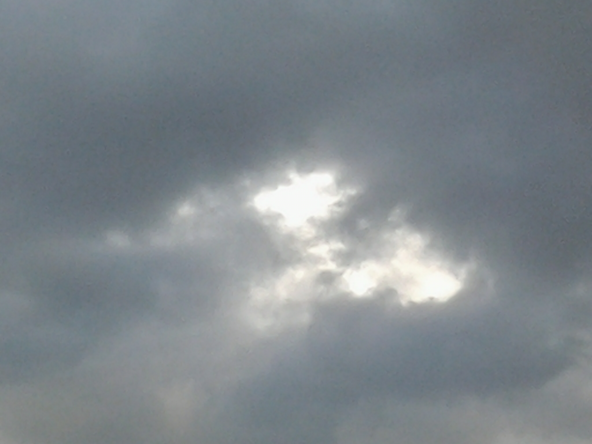Cloudy sky with sunlight peeking through.
