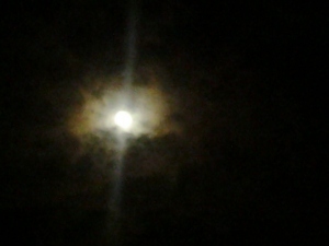 Bright moon surrounded by dark night clouds.