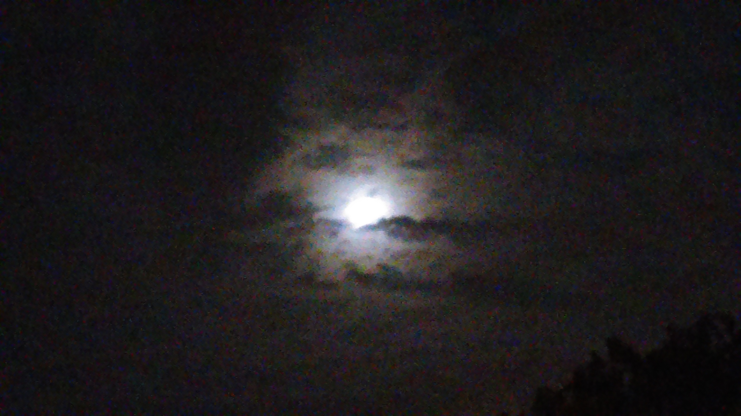 Full moon partially obscured by clouds.