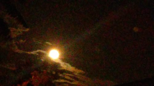 Bright moon in a cloudy night sky.