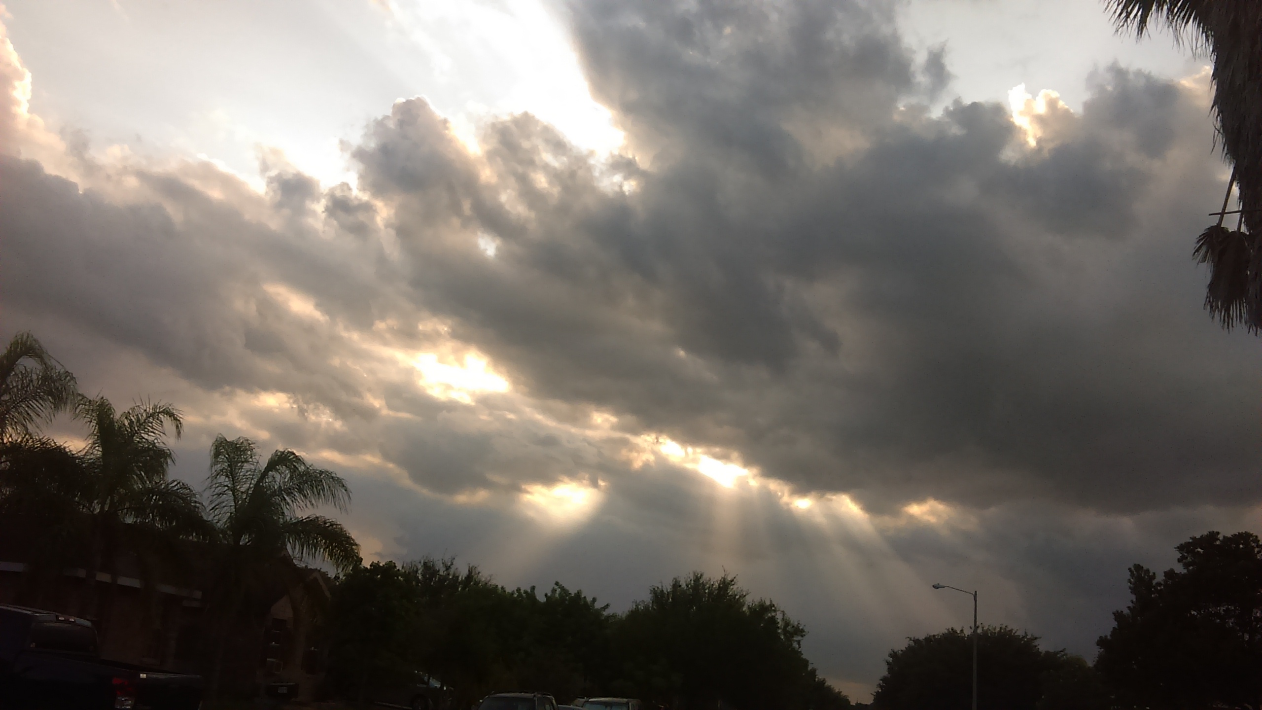 Cloudy sky with sun rays shining through.