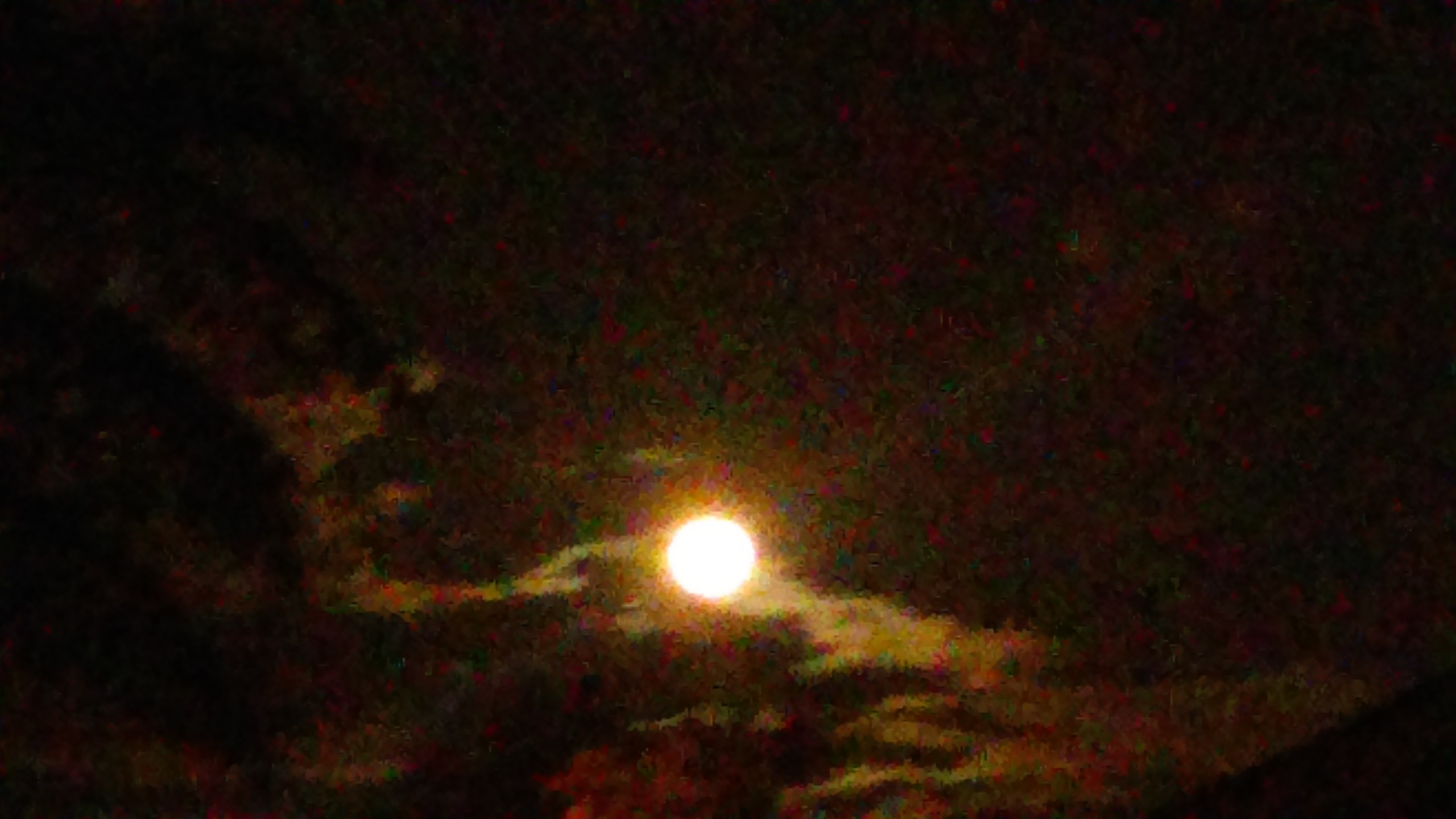 Bright moon in cloudy night sky.