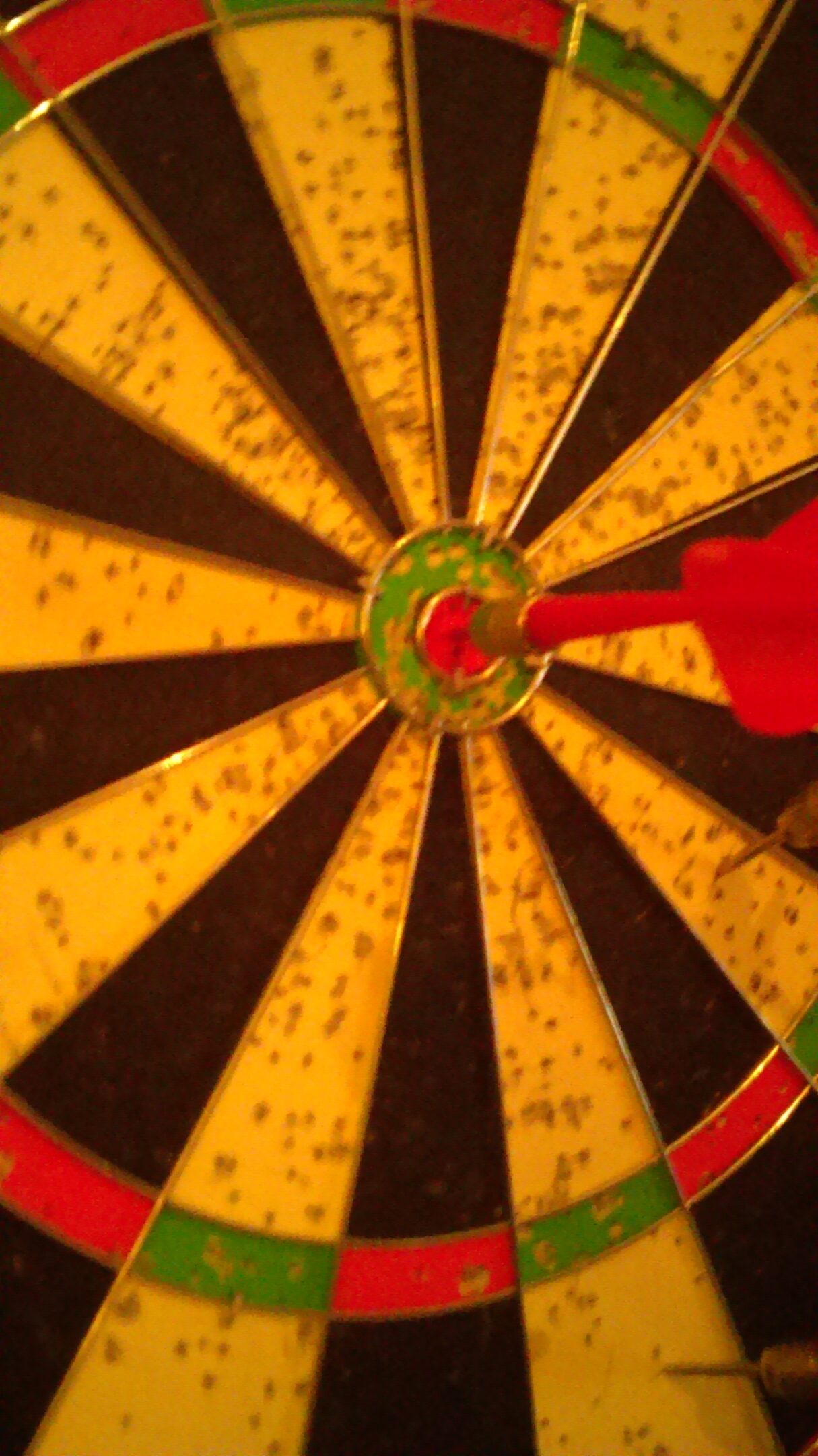 Dartboard with dart hitting the bullseye.