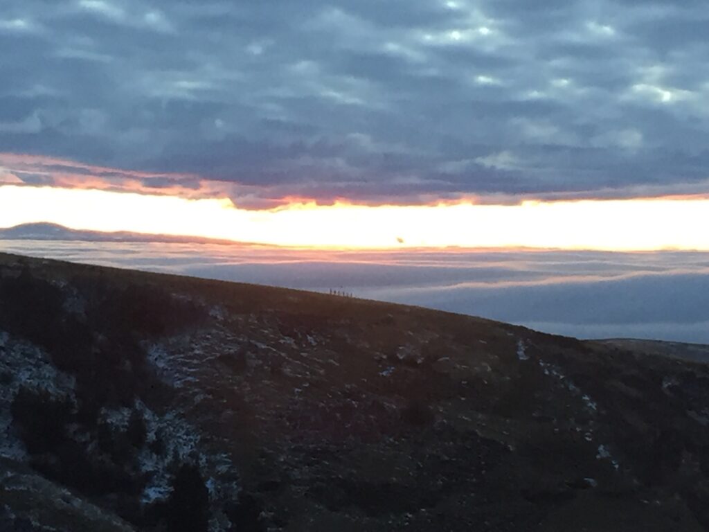 Mountain landscape at sunset with cloudy sky.