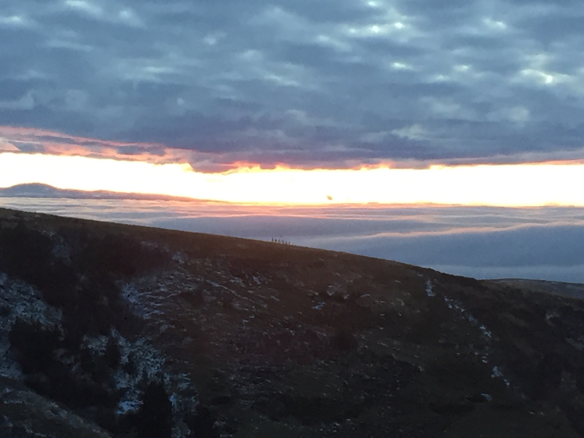 Mountain landscape at sunset with cloudy sky.