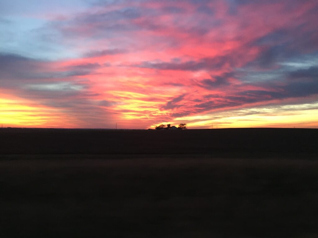 Vibrant sunset over a silhouetted landscape.