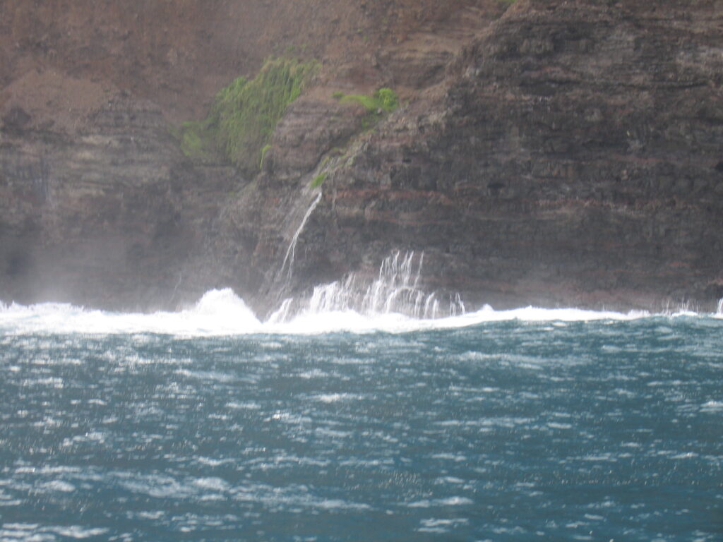 Water splashing against rocky coastal cliff.