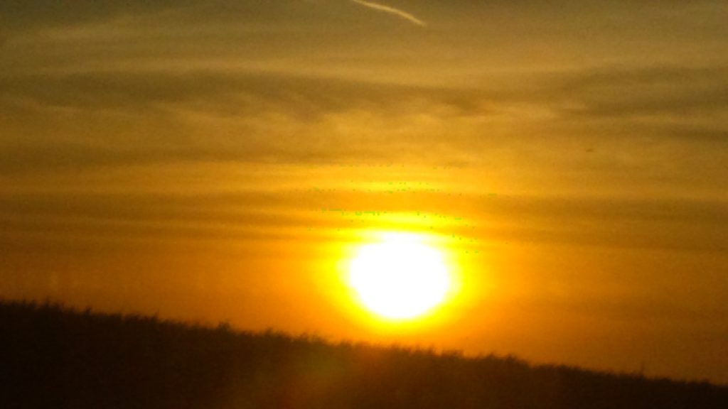 Sunset over horizon with golden sky.