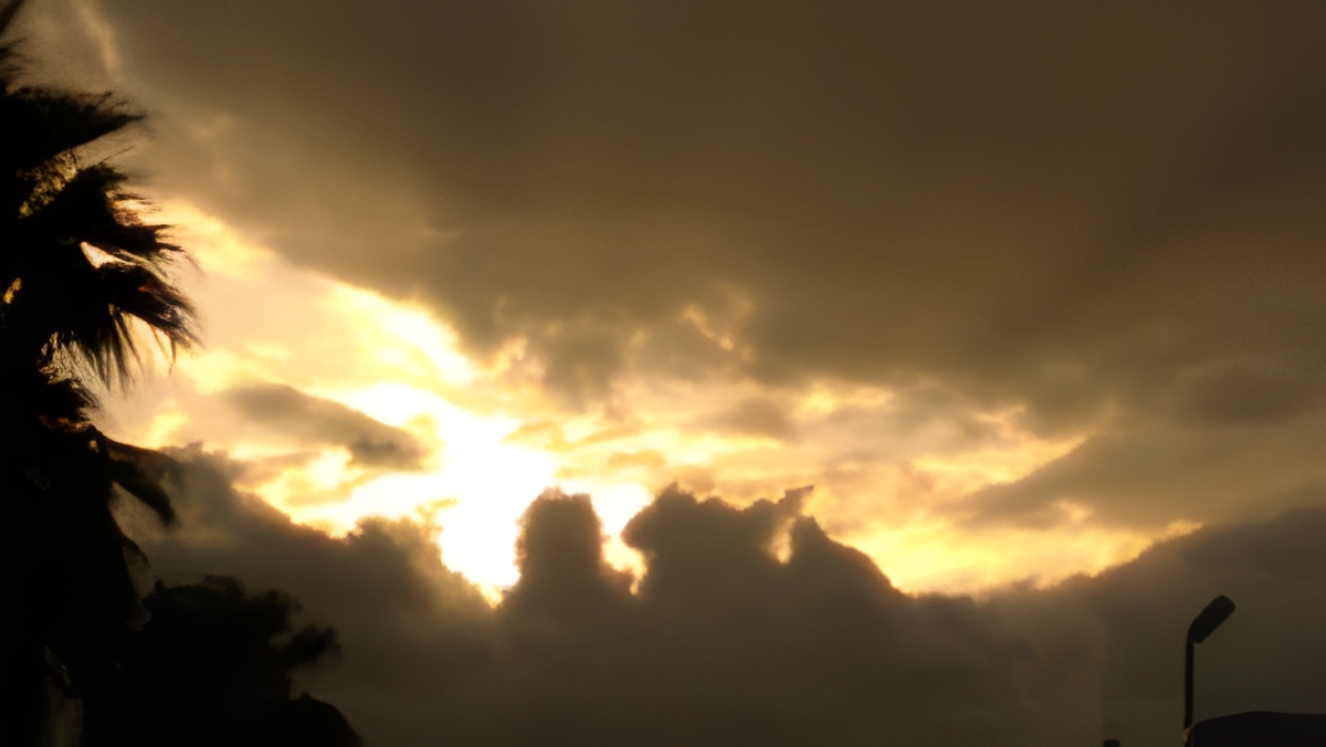 Sunset with dramatic clouds and silhouetted trees.