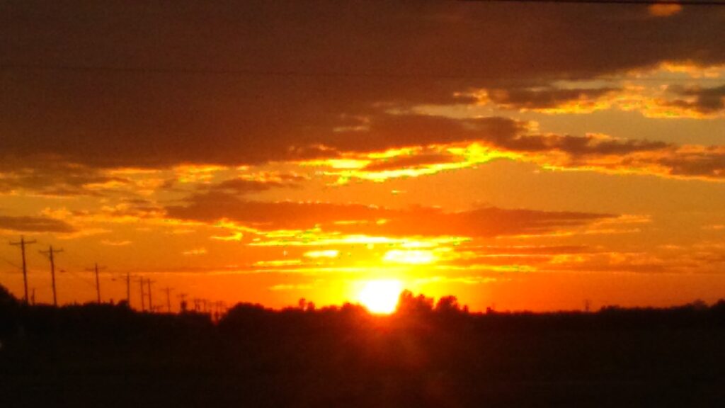 Sunset over horizon with orange clouds.