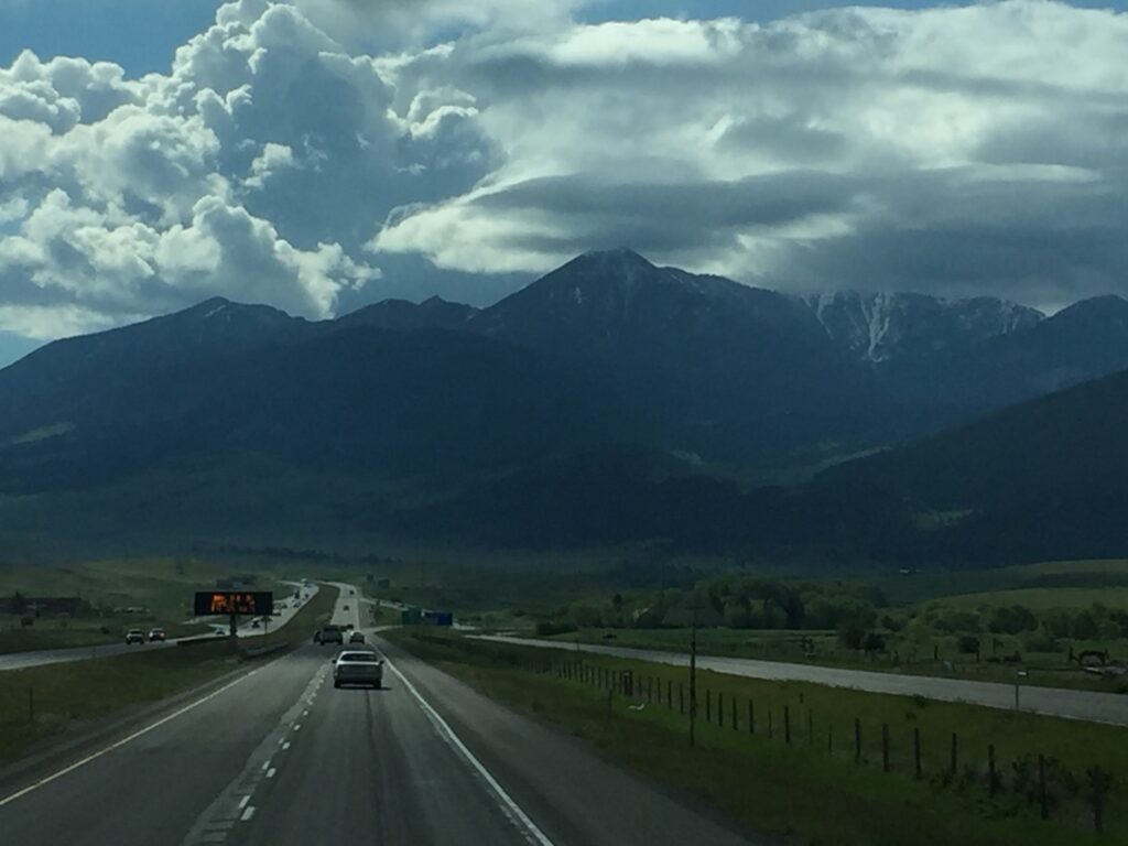 Mountain highway under cloudy sky.