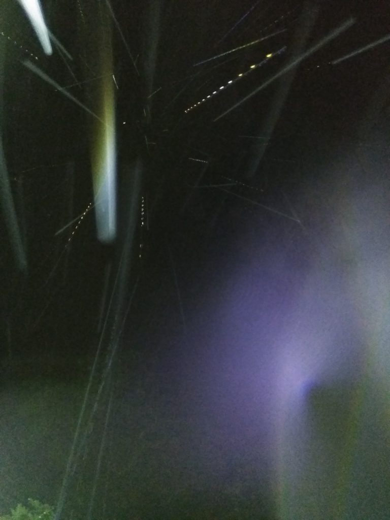 Bright light streaks in dark night sky.