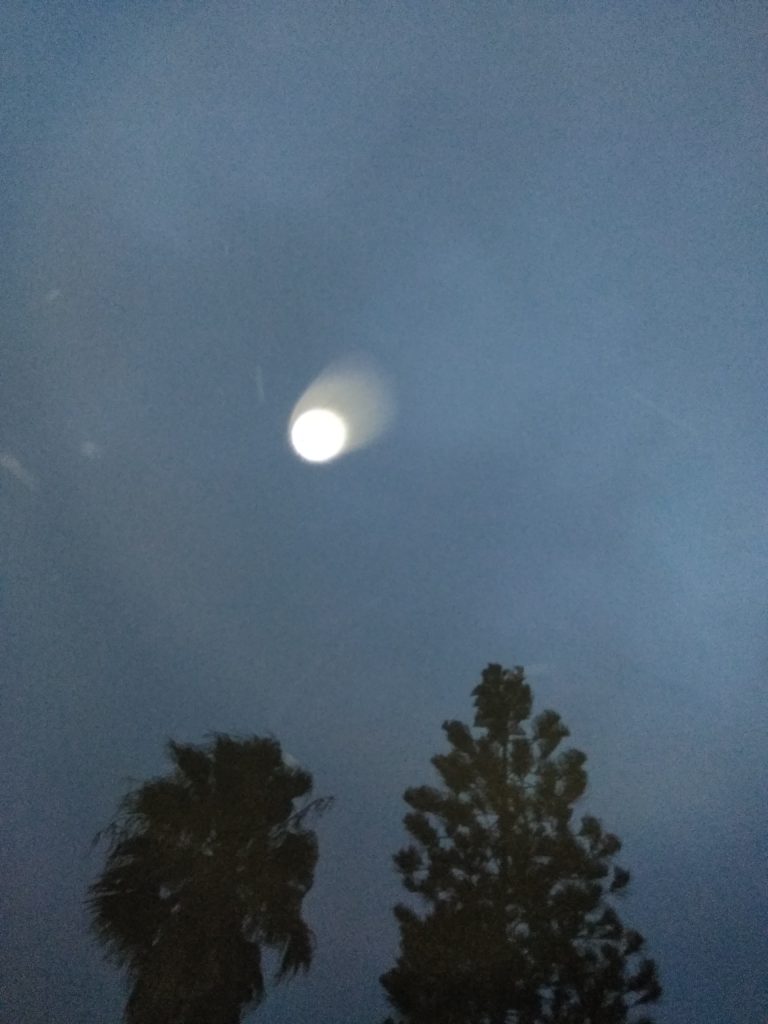 Bright moon in cloudy night sky.