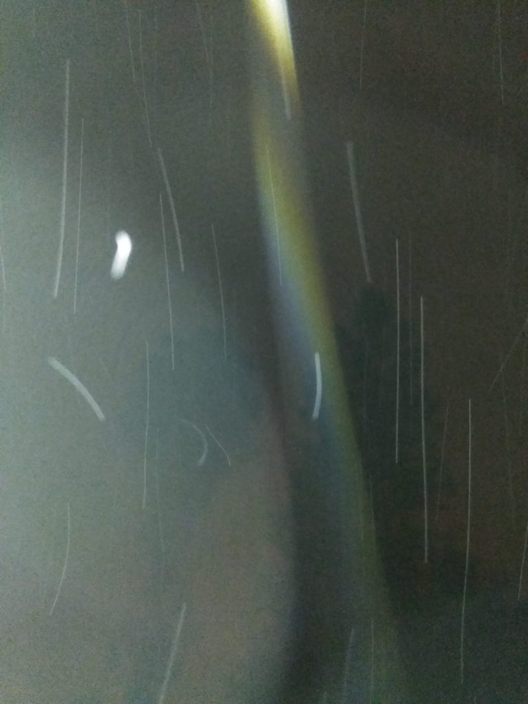 Blurry night sky with light streaks.