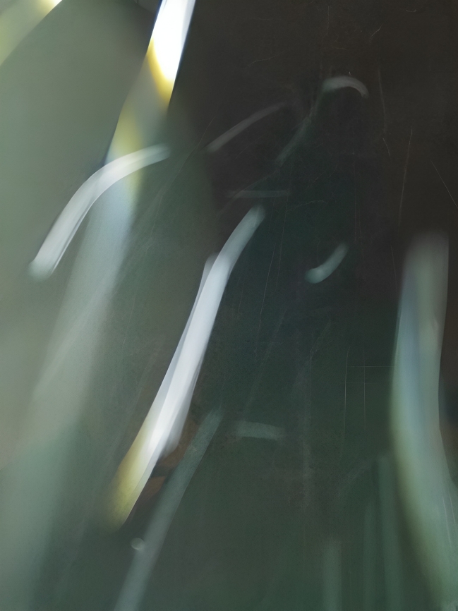 Abstract motion-blurred green light streaks on dark