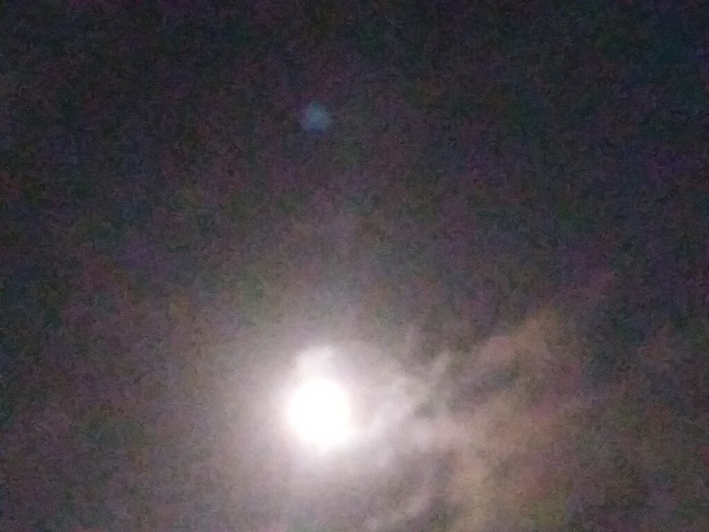 Bright moon in a cloudy night sky.