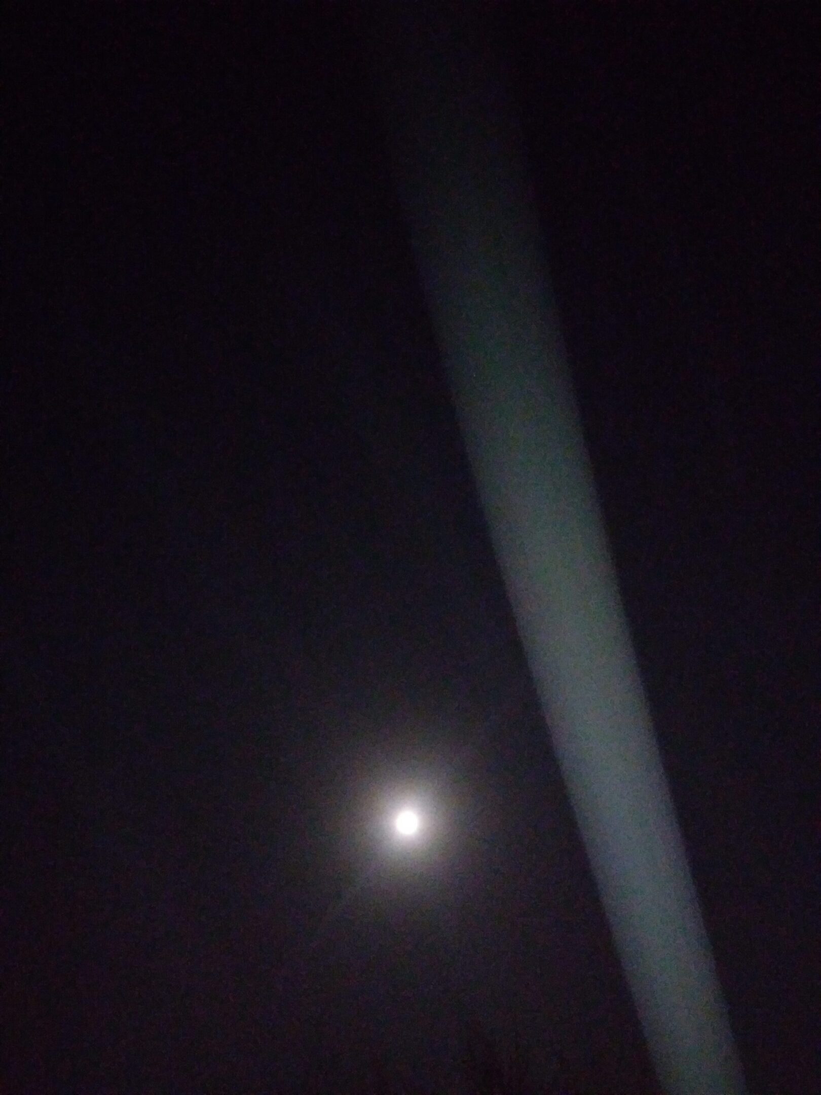 Moon shining in dark night sky, light beam.