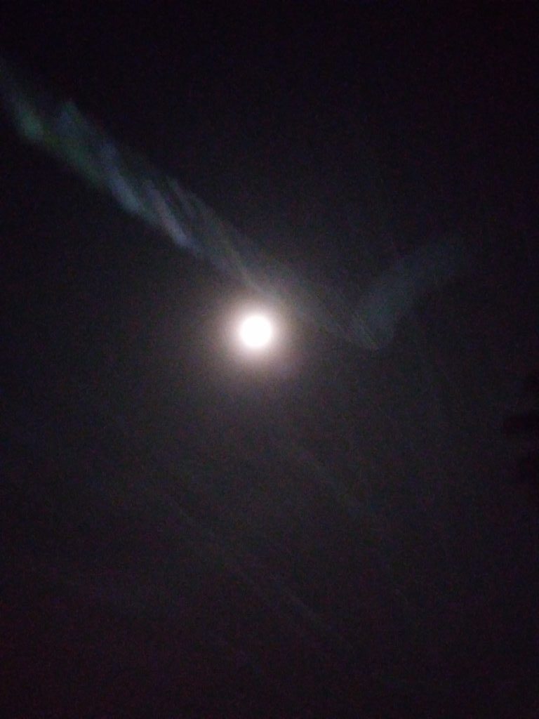Blurry night sky with bright moon.