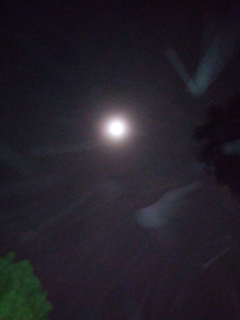 Bright moon in a cloudy night sky.