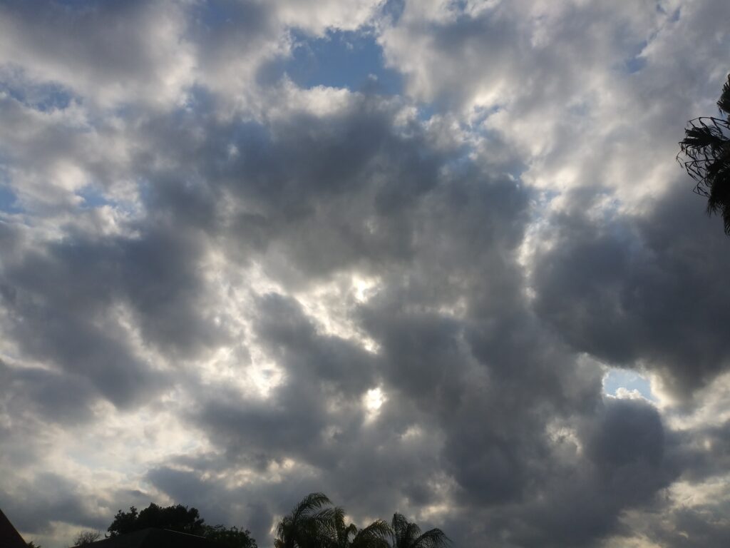 Cloudy sky with scattered sunlight patches.