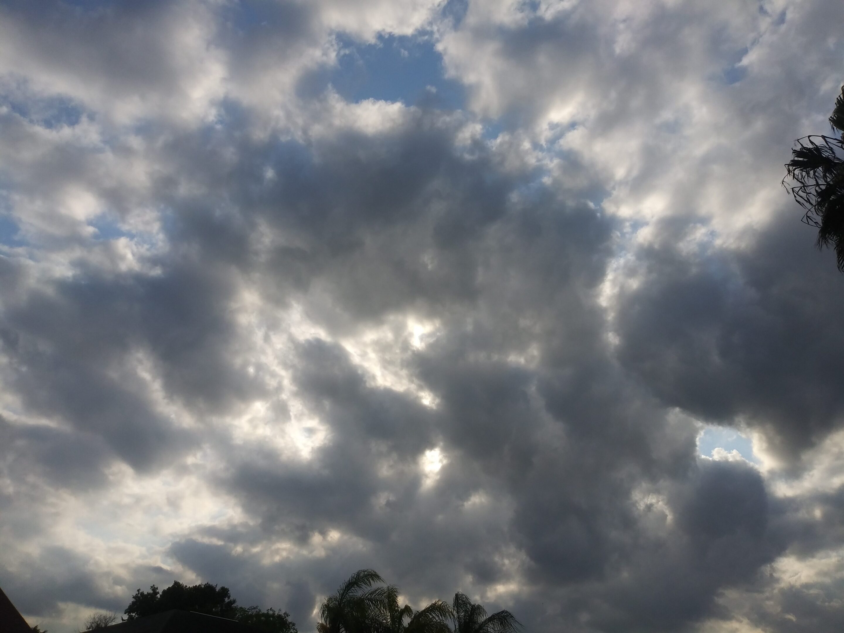 Cloudy sky with scattered sunlight patches.